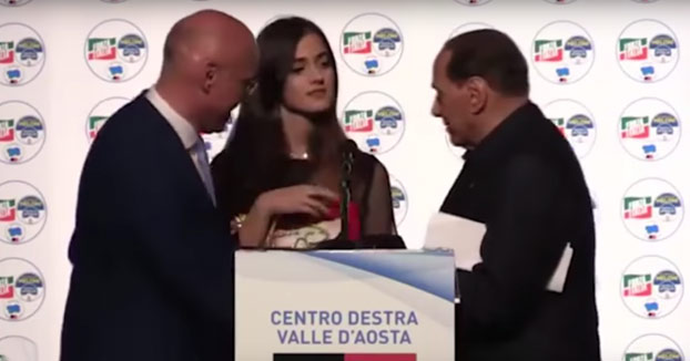 Momento en el que Berlusconi está recibiendo unos regalos y dice que prefiere quedarse con la chica