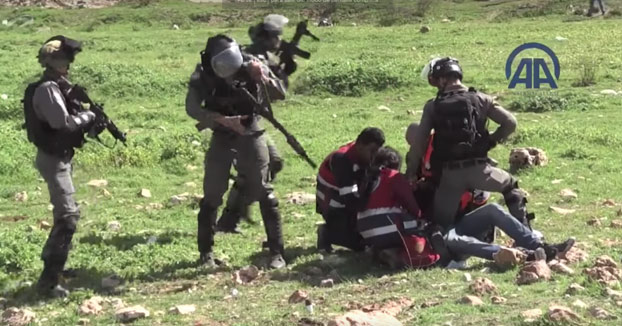 Paramédicos palestinos luchando contra los soldados de ocupación para rescatar a los heridos