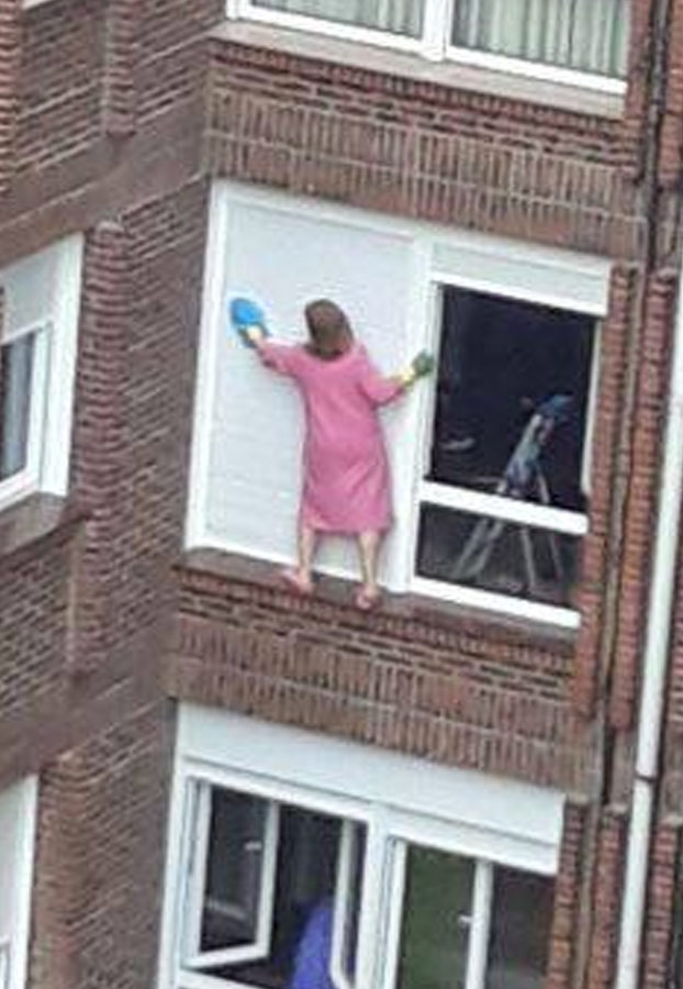 Señora de Santander jugándose la vida limpiando las ventanas de su casa