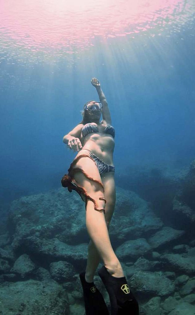 Un pulpo se agarra a la pierna de una buceadora durante una sesión de buceo en Hawaii