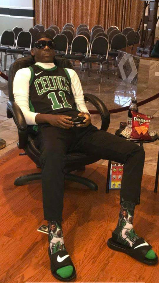 Un fan de los Boston Celtics fue velado sentado en un sillón jugando a la consola con la camiseta de su equipo