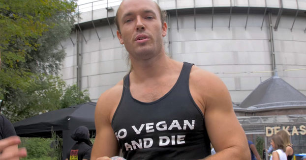 Un hombre come carne cruda en medio de un festival de comida vegana