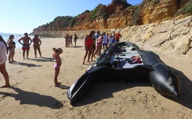 Una patera de inmigrantes desembarca en una playa abarrotada de Chiclana