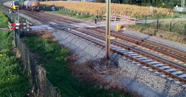 Un ciclista cruza las vías con la barrera bajada y casi es arrollado por un tren