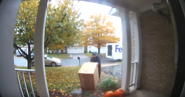 Repartidor de FedEx llevando un paquete marcado como frágil
