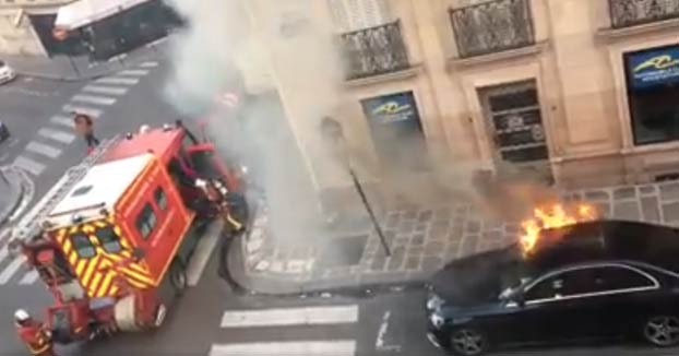 Actuación de unos bomberos para apagar un Mercedes en llamas en la calle