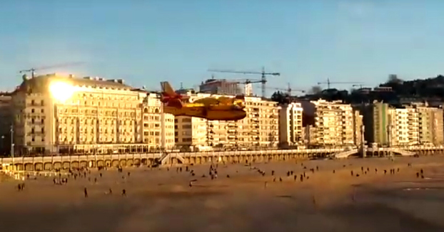 Un hidroavión carga agua en la playa de la Concha a pocos metros de paseantes y bañistas