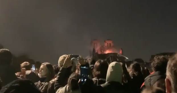 El pueblo francés cantando en uno de los puentes frente a Notre Dame ardiendo
