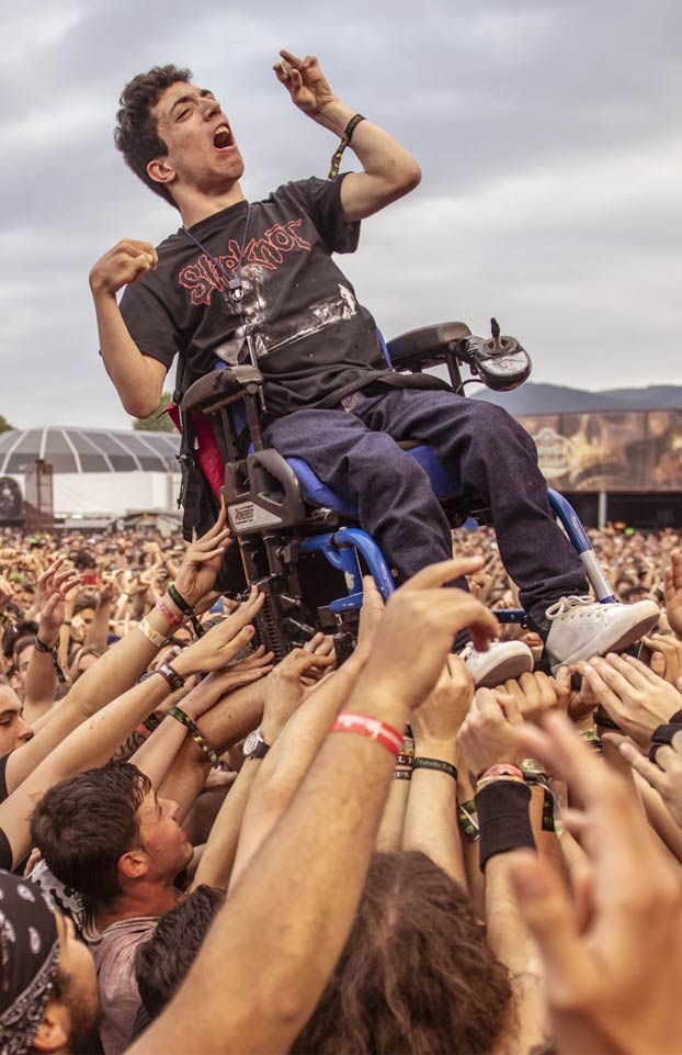 Momento en el que decenas de personas llevan en volandas a un chico en silla de ruedas en el concierto de Arch Enemy durante el Resurrection Fest