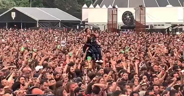 Momento en el que decenas de personas llevan en volandas a un chico en silla de ruedas en el concierto de Arch Enemy durante el Resurrection Fest
