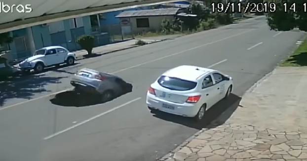 Un coche cae en un socavón que segundos antes había producido un camión
