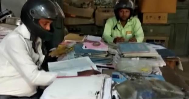 Unos empleados indios usan casco de moto en sus oficinas por miedo a que se les caiga encima el edificio