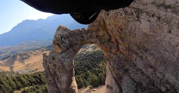 El paracaidista Alejandro Villar atraviesa un agujero de tres metros de ancho mientras hace wingsuit en el Pirineo Aragonés