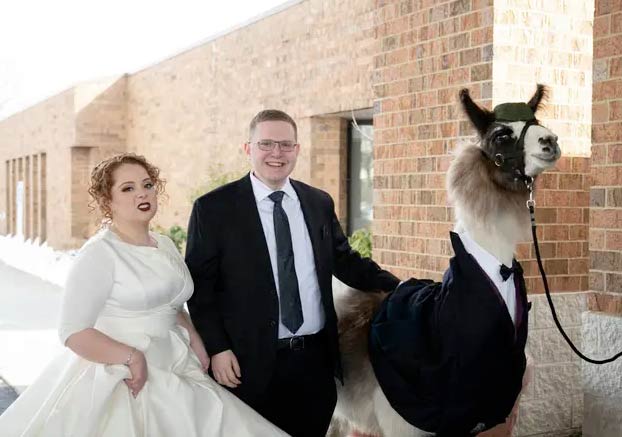 Un hombre se planta con una llama vestida con un esmoquin en la boda de su hermana