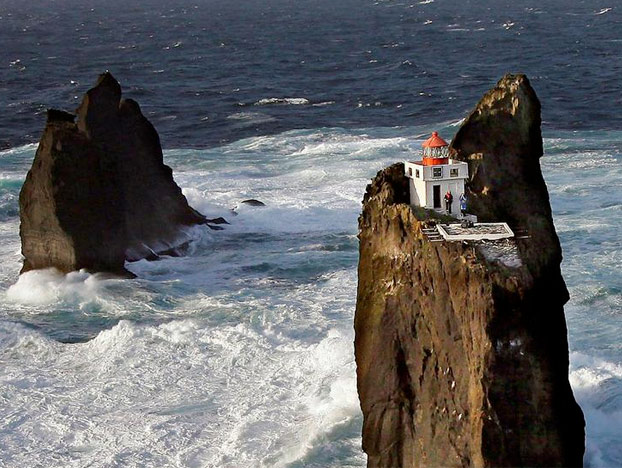 Un faro sobre una roca en medio del brusco oleaje de Islandia (Islas Westman)