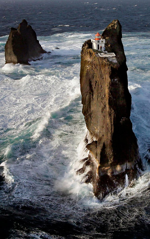 Un faro sobre una roca en medio del brusco oleaje de Islandia (Islas Westman)