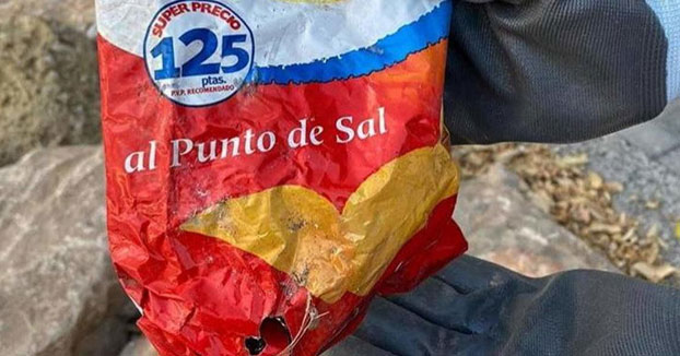 Hallan en las rocas de una playa valenciana una bolsa de patatas de más de 22 años