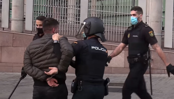 Policía dando un cabezazo con el casco a un detenido esposado e inmovilizado en Madrid