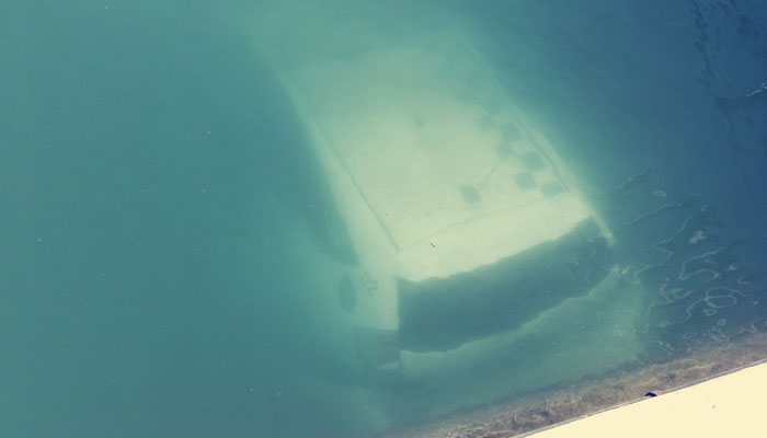 Un coche patrulla de la policía de Vilanova i la Geltrú acaba bajo el mar en el puerto durante un operativo contra un botellón