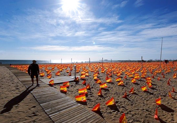 Una playa de Valencia amanece con 53.000 banderas de España en recuerdo de las víctimas de la pandemia