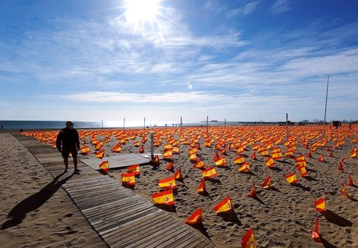Una playa de Valencia amanece con 53.000 banderas de España en recuerdo de las víctimas de la pandemia