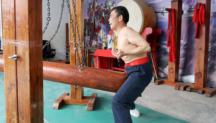 El pequeño grupo de maestros de artes marciales que practica el 'iron crotch', recibir un golpe en la entrepierna con un tronco de 40 kilos