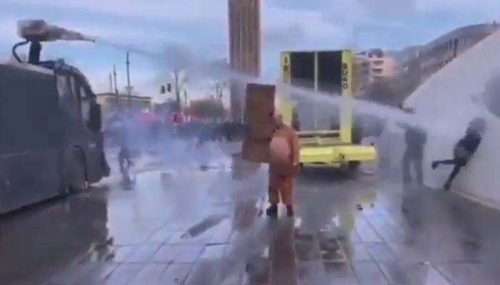 Una mujer es golpeada por un cañón de agua desde muy cerca durante las protestas en Países Bajos contra el toque de queda
