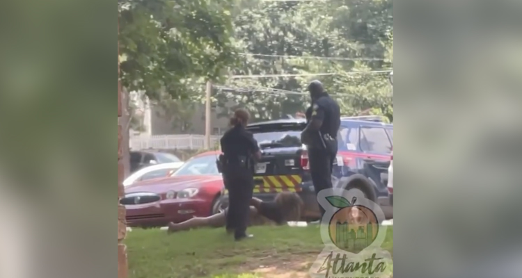 Un policía le propina una patada en la cara a una mujer esposada y tumbada boca abajo